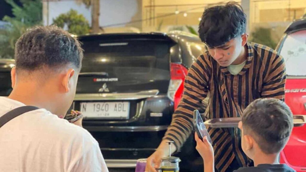 staff yang menyajikan hidangan dengan baju adat jawa